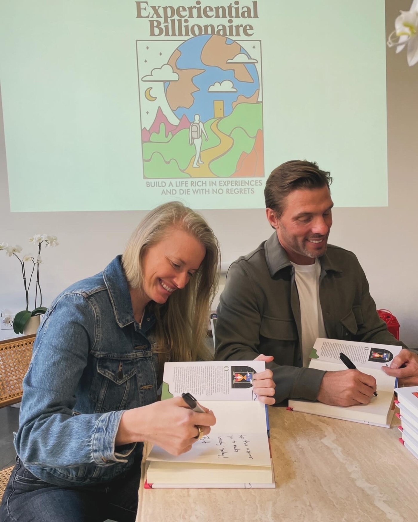 Bridget Hilton and Joe Huff signing copies of Experiential Billionaire