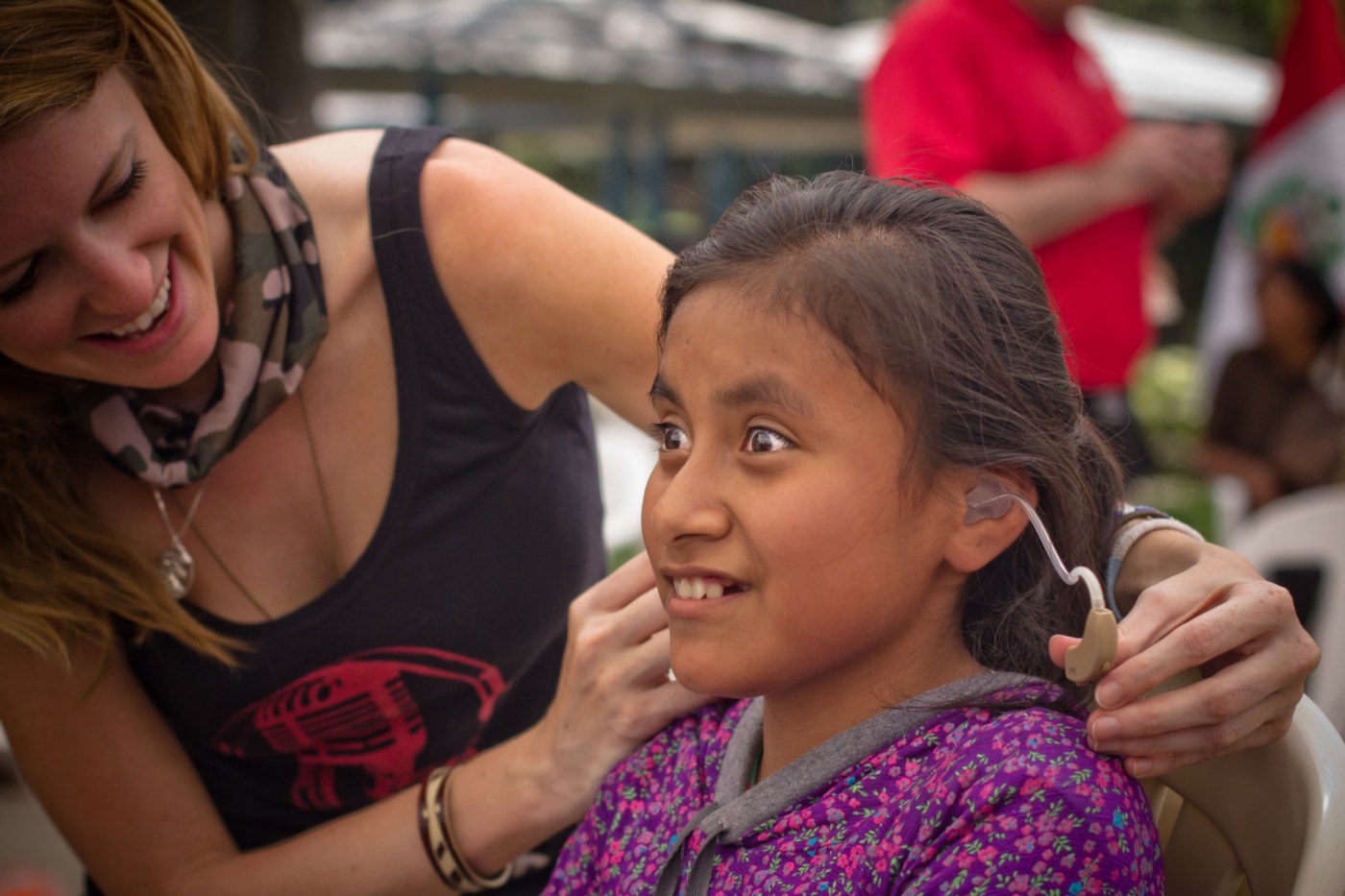 Bridget fitting a hearing aid on a girl in Peru