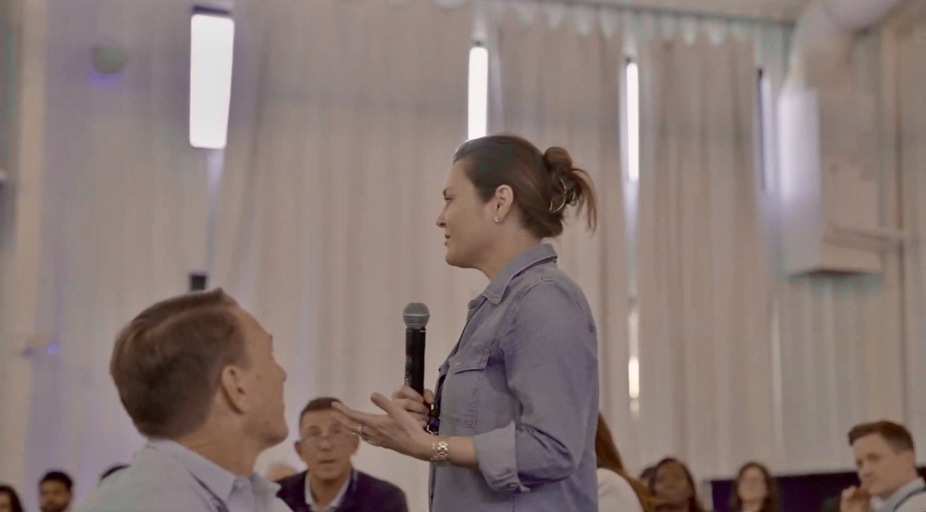 A workshop participant holding a microphone, sharing her someday with the room